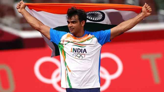 Neeraj Chopra of India celebrates with his national flag after winning gold